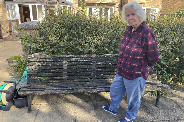 Maggie Jones by a bench in the garden at Oak House in Putney